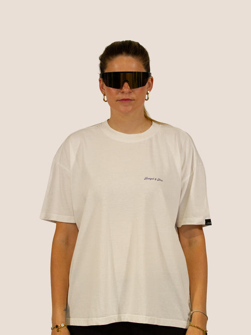 Frau im Off-White Heavy Tee von Bengel & Göre mit Brust-Schriftzug und Rennrad-Sonnenbrille, Vorderseite.
