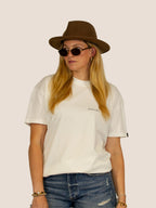 Frau im Off-White Bengel & Göre Heavy Tee mit braunem Filzhut und runder Sonnenbrille, Western-Look, Vorderseite.