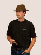 Mann im schwarzen Bengel & Göre Heavy Tee mit Filzhut und Zigarre, Western-Look, Vorderseite.