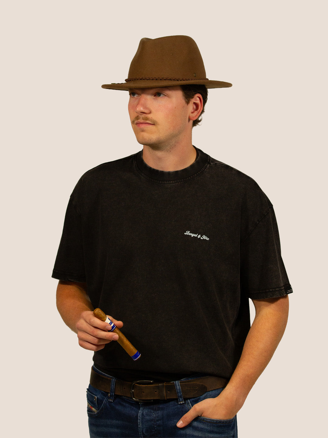 Mann im schwarzen Bengel & Göre Heavy Tee mit Filzhut und Zigarre, Western-Look, Vorderseite.