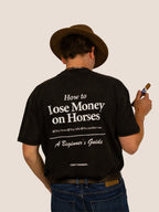 Rückseite des schwarzen Heavy Tee „How To Lose Money On Horses“ mit weißem Text-Print, Mann mit Zigarre.