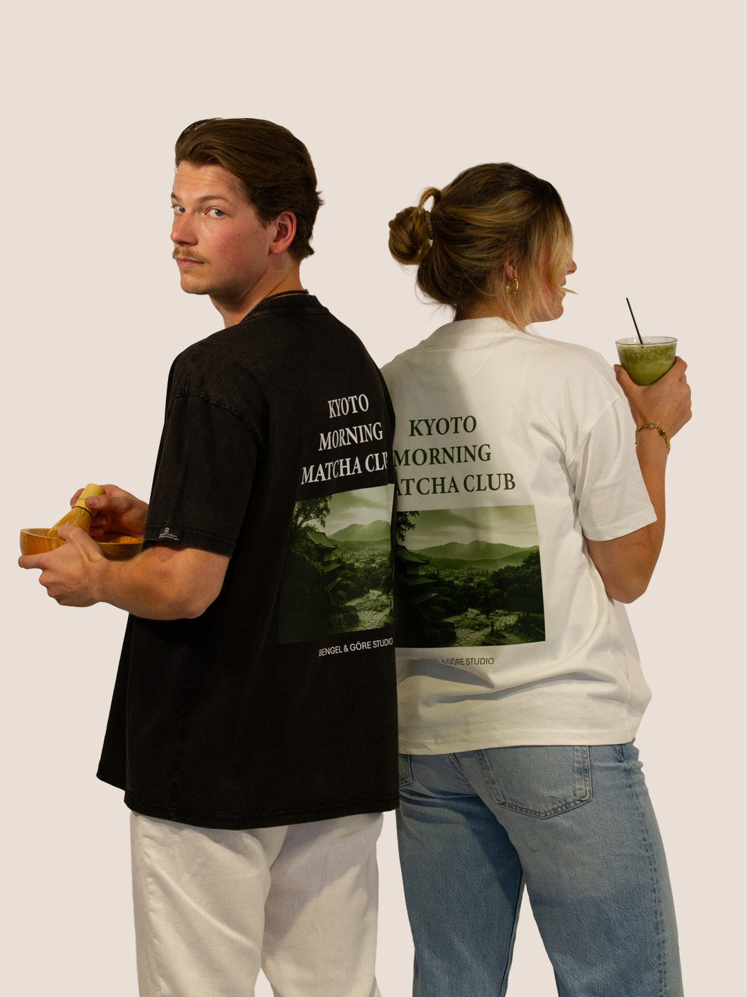Paar Rücken an Rücken in „Kyoto Morning Matcha Club“ Heavy Tees von Bengel & Göre in Schwarz und Off-White.