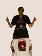 Zwei Personen in Bengel & Göre „Reformer Pilates“ Heavy Tees, Rückenprints in Schwarz und Off-White.