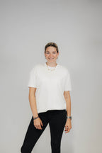 Frau im Off-White Bengel & Göre Heavy Tee mit Brust-Schriftzug und schwarzer Jeans, Vorderseite.