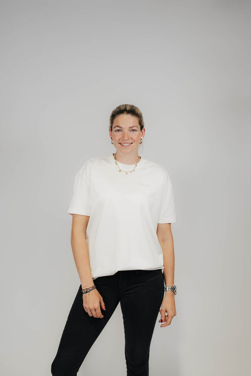 Frau im Off-White Bengel & Göre Heavy Tee mit Brust-Schriftzug und schwarzer Jeans, Vorderseite.