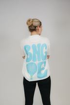 Frau im Off-White „BNGOE Padel“ Heavy Tee von Bengel & Göre, hellblauer Rückenprint.
