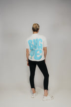 Frau im Off-White „BNGOE Padel“ Heavy Tee, Ganzkörper-Rückansicht mit schwarzer Jeans.