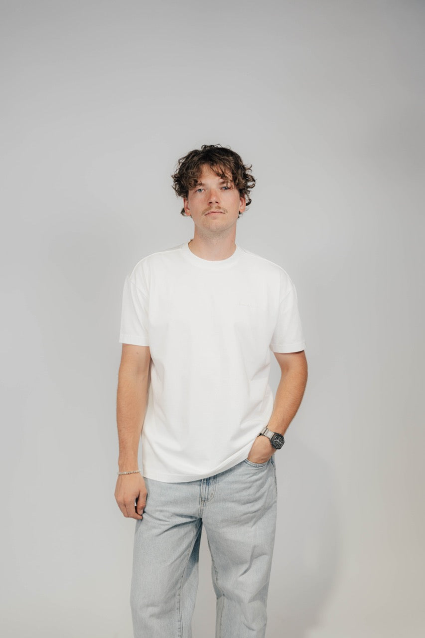 Mann im Off-White Bengel & Göre Heavy Tee mit Ton-in-Ton-Brust-Schriftzug, Vorderseite.