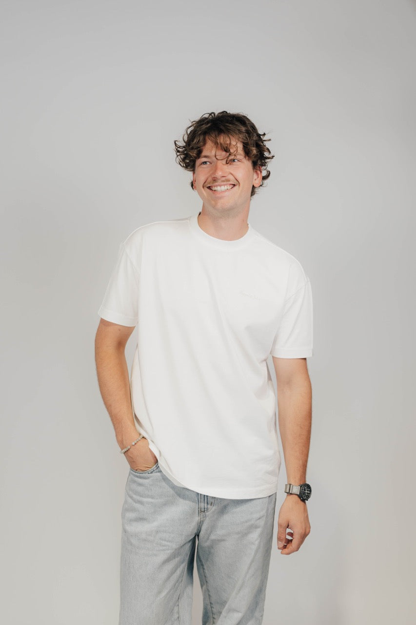Lächelnder Mann im Off-White Bengel & Göre Heavy Tee mit Brust-Schriftzug, Vorderseite.